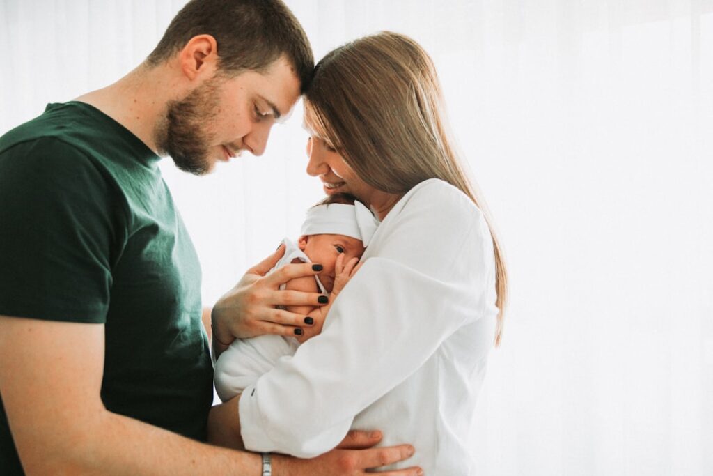 a man and woman holding a baby in their arms