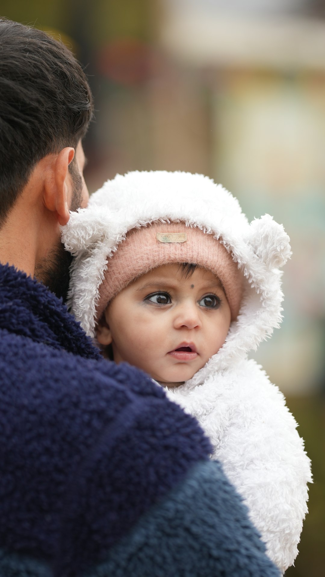 Papa houdt baby vast in warme winterkleding