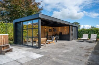 Houten tuinkamer met openslaande deuren in de tuin