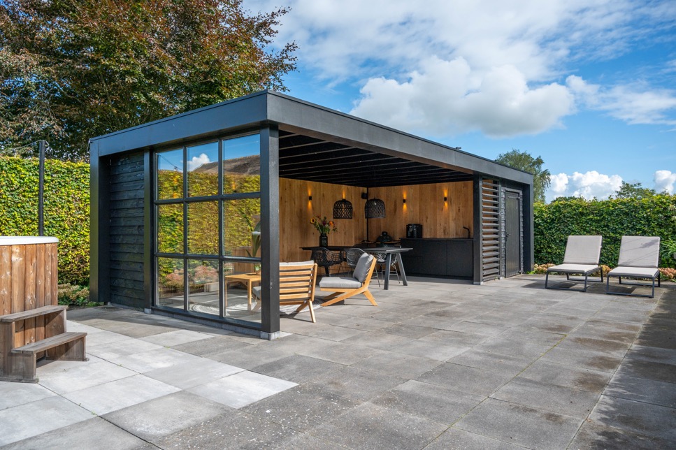 Houten tuinkamer met openslaande deuren in de tuin