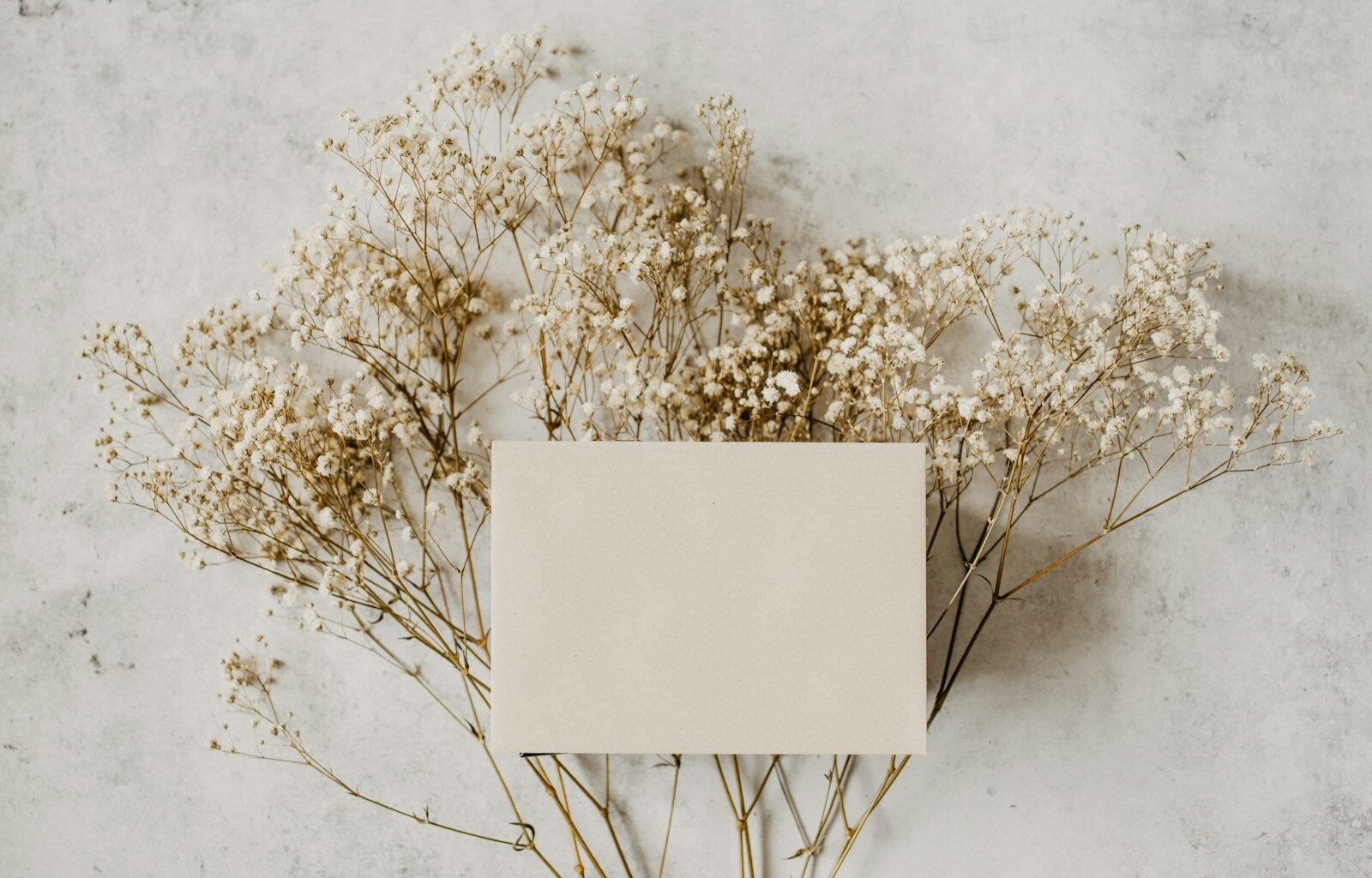 Ingepakt cadeautje met een handgeschreven kaartje en bloemen op tafel