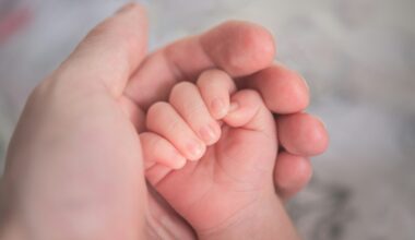 Babyhandje dat de vinger van een ouder vasthoudt
