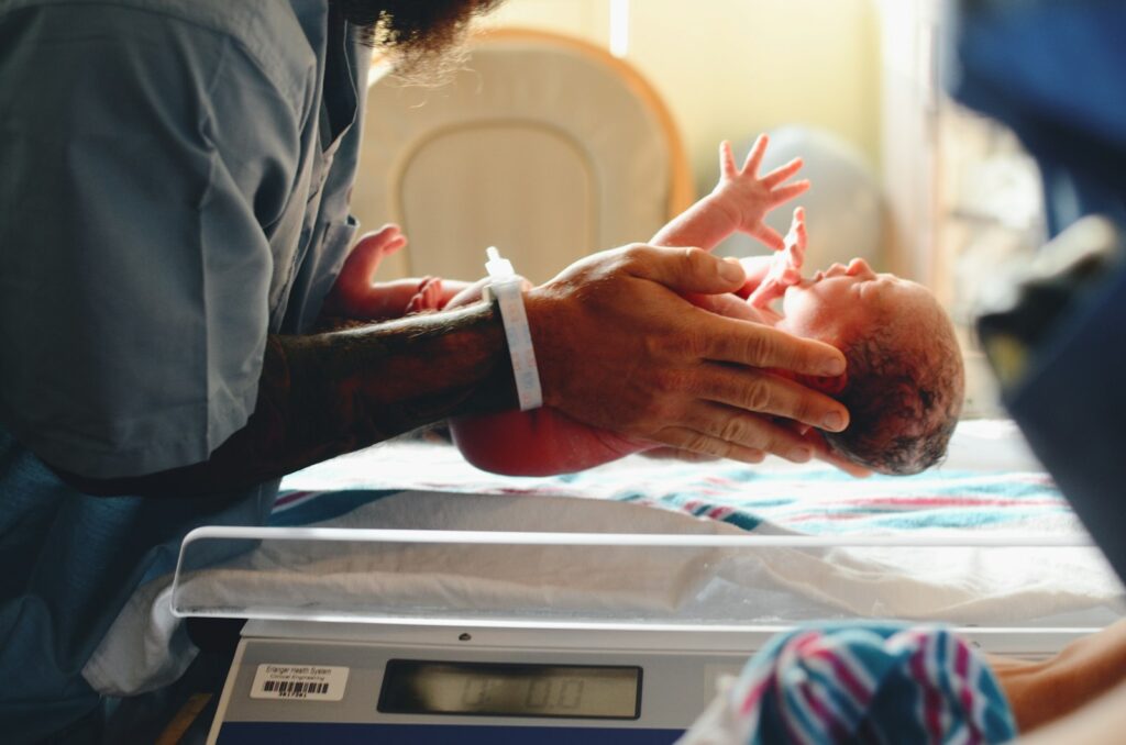 Ouder houdt een pasgeboren baby dicht tegen zich aan
