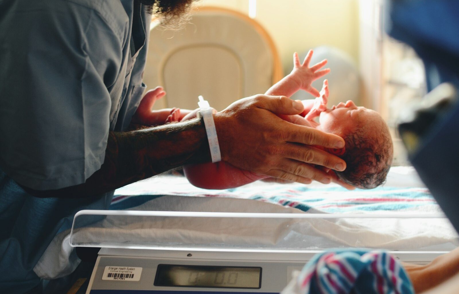 Ouder houdt een pasgeboren baby dicht tegen zich aan