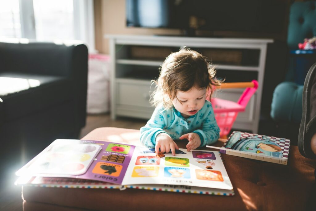 Ouder leest een prentenboek voor aan een kind op de bank