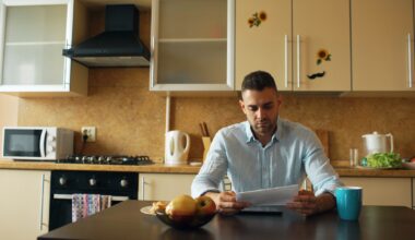 Moeder aan de keukentafel met papieren en een laptop
