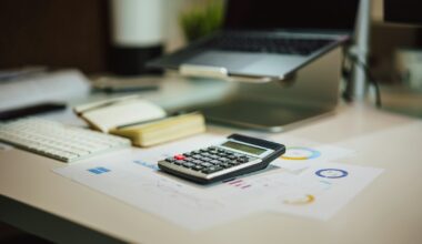 Ouder rekent aan de keukentafel met een laptop en papieren de opvangkosten uit