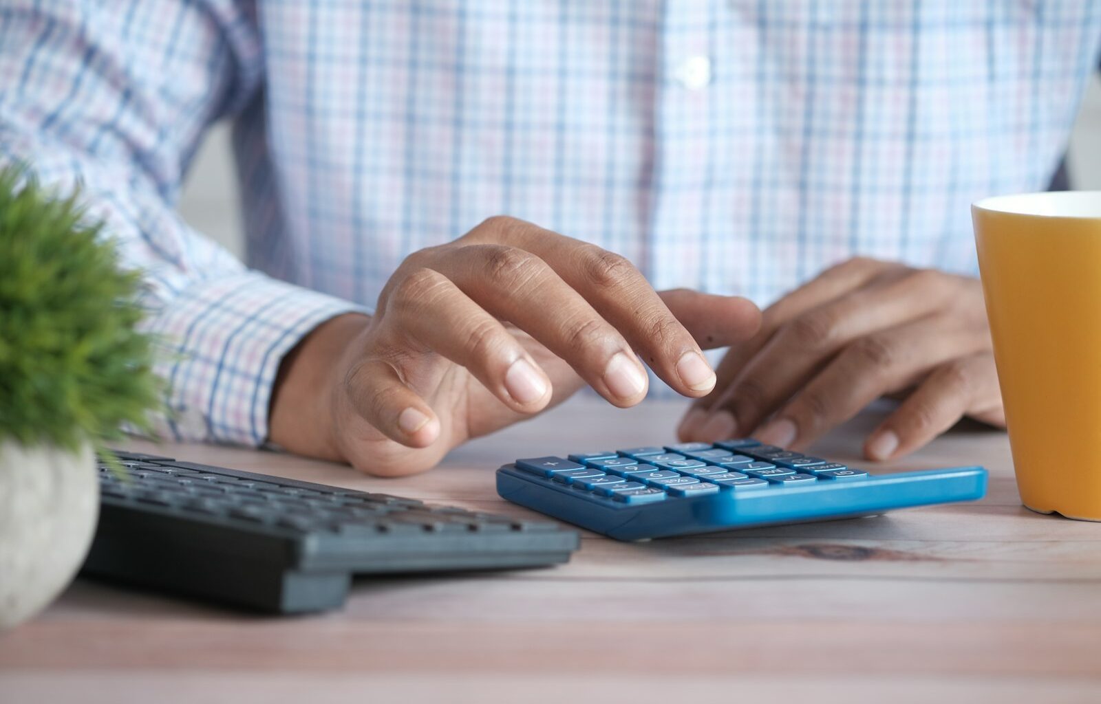 Ouder rekent aan de keukentafel met rekeningen en een laptop