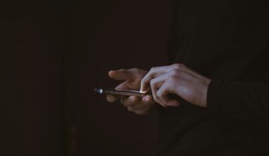 Handen van een tiener met een smartphone in het donker