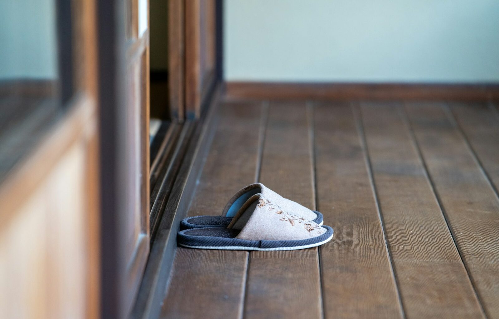 Kindersloffen naast elkaar op een houten vloer