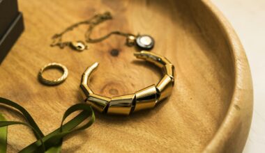 Een gouden armband, een ring en een fijn kettinkje op een houten schaaltje