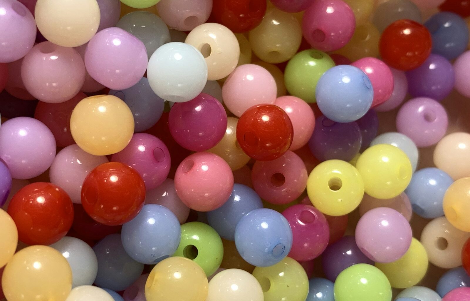 Gekleurde waterparels in een bak met kinderhanden