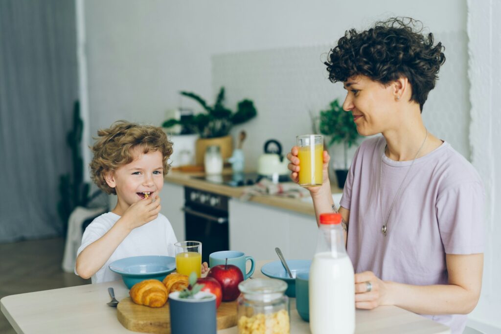 Moeder met twee jonge kinderen aan de ontbijttafel