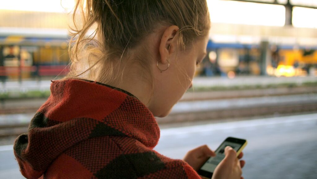 Tiener kijkt 's avonds op haar smartphone