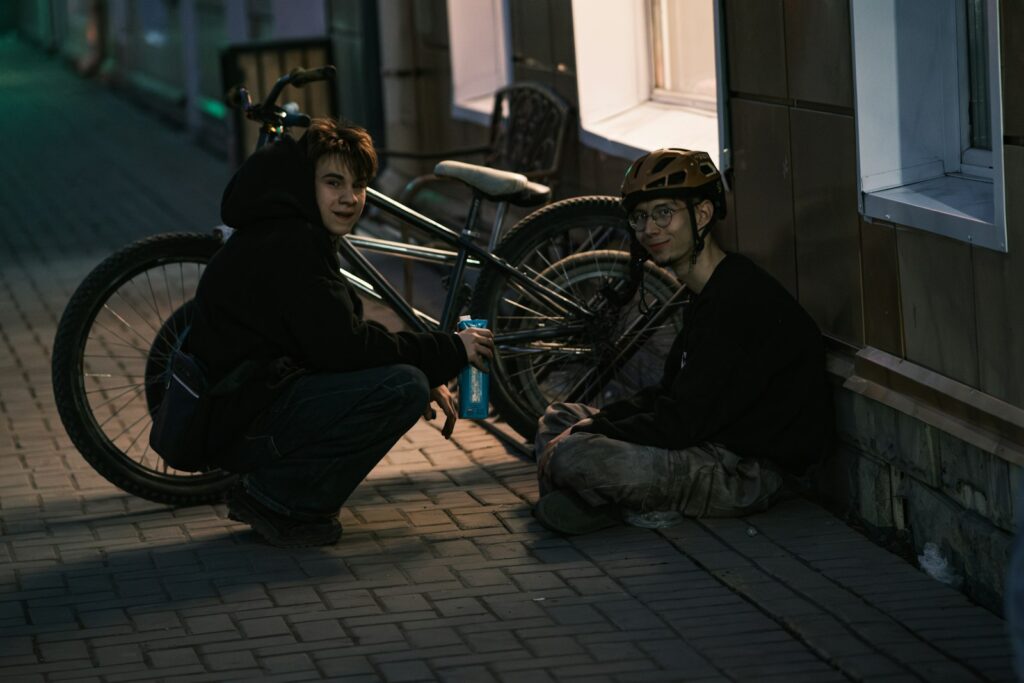 Tieners fietsen 's avonds samen naar huis onder straatverlichting