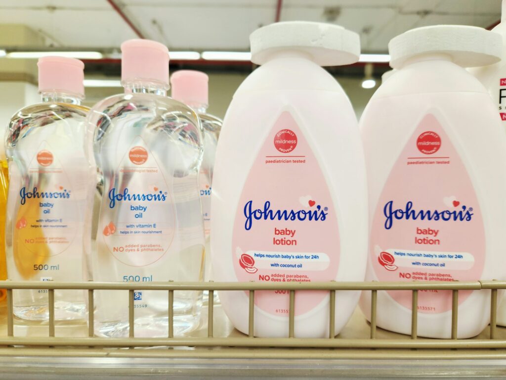 Baby in een badje met een washandje en verzorgingsproducten ernaast