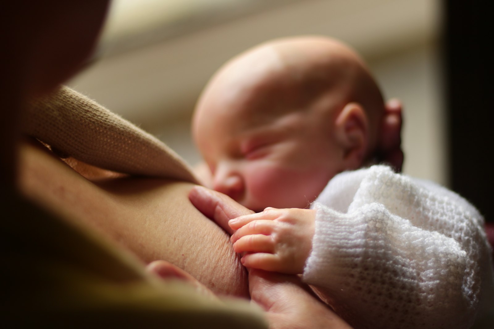 Baby drinkt aan de borst bij de moeder