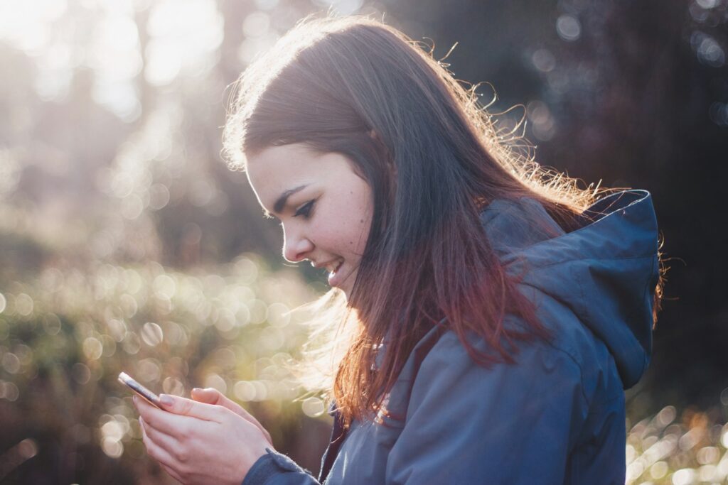Meisje van een jaar of twaalf kijkt op haar smartphone
