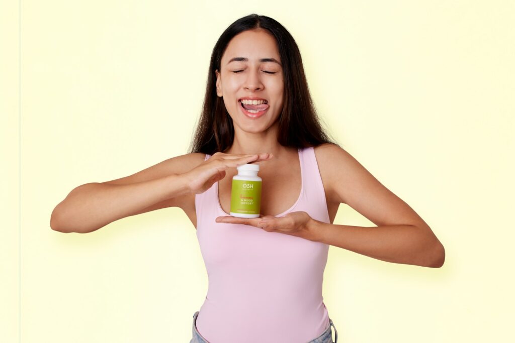 Vrouw kijkt bezorgd naar een potje supplementen aan tafel