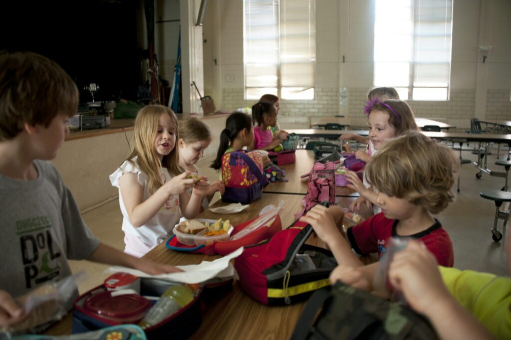 Kinderen eten hun lunch aan tafel in de klas