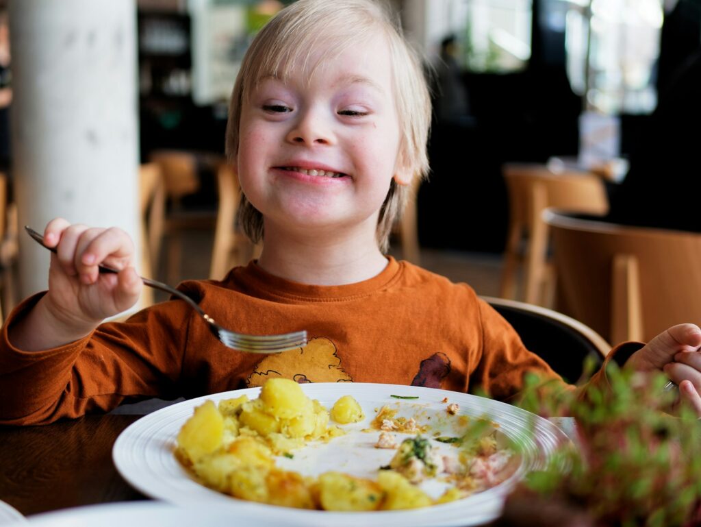 Kind kijkt sceptisch naar een bord met groente op de keukentafel
