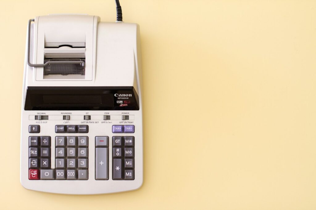 Ouder rekent met een rekenmachine en kassabonnen aan de keukentafel