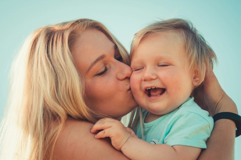 Lachende baby op een deken die zijn moeder aankijkt