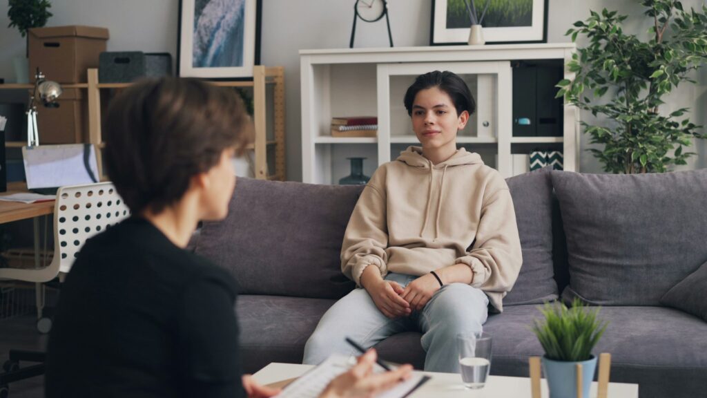 Moeder en zoon in gesprek met een kinderpsycholoog in een spreekkamer