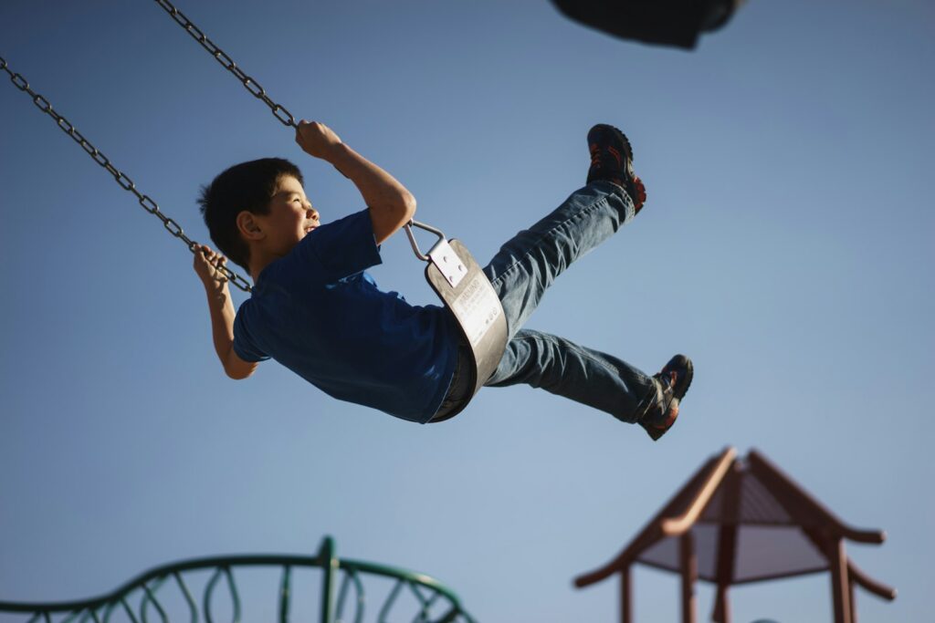 Kind zit alleen op een bankje op het schoolplein terwijl anderen spelen