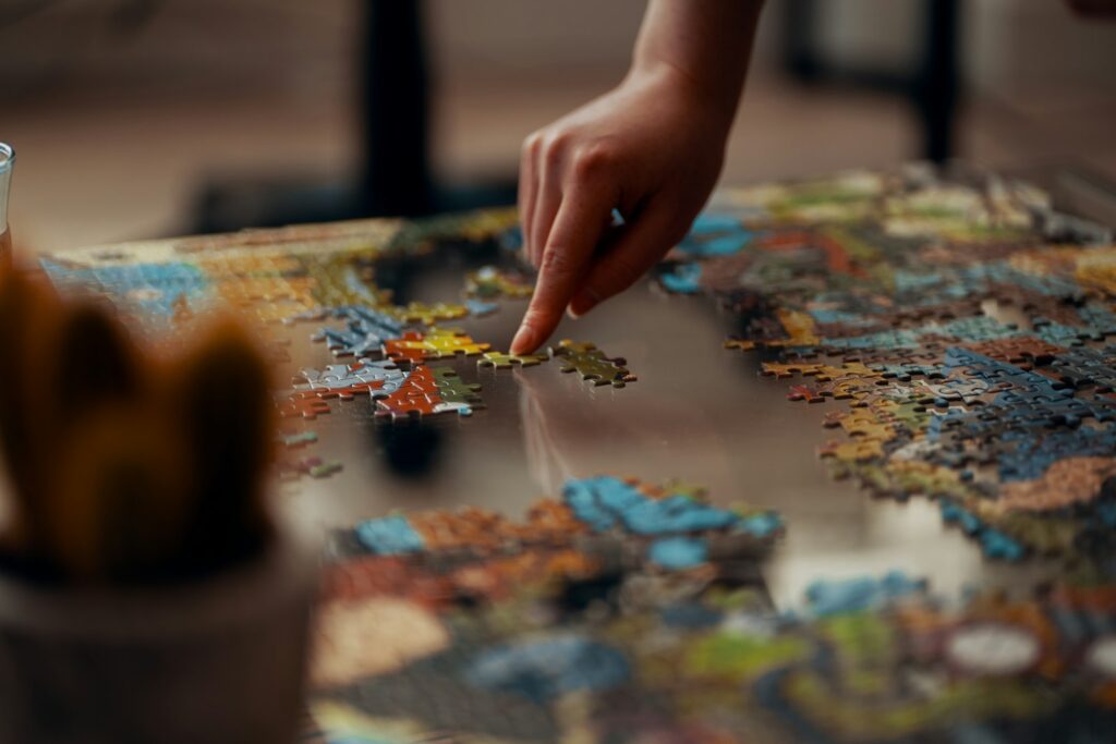 Jong kind dat geconcentreerd aan een puzzel werkt aan tafel