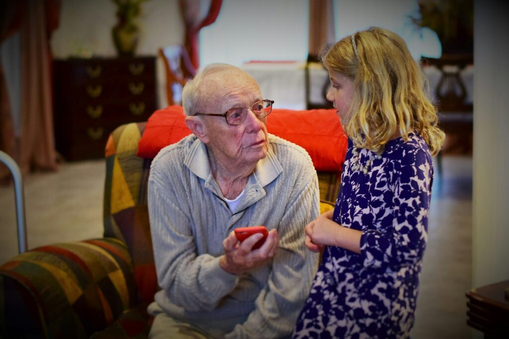 Opa en kleinkind spelen samen een kaartspel aan de keukentafel