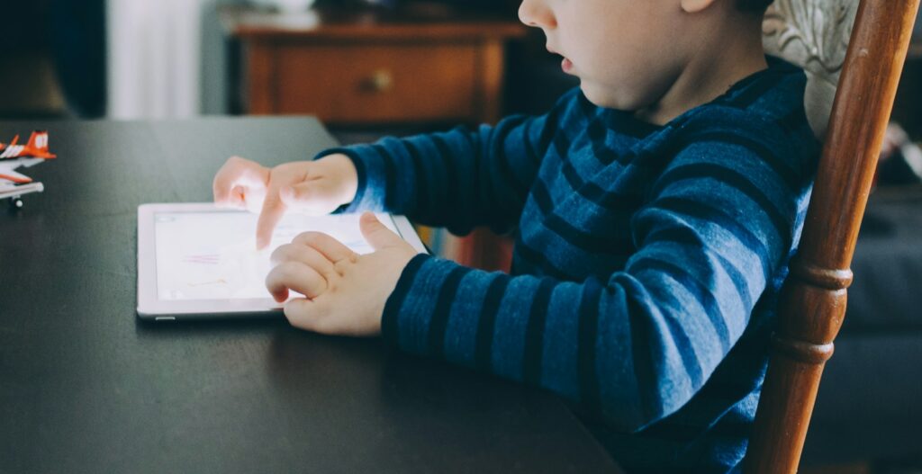 Kind kijkt 's avonds op de bank naar een tablet