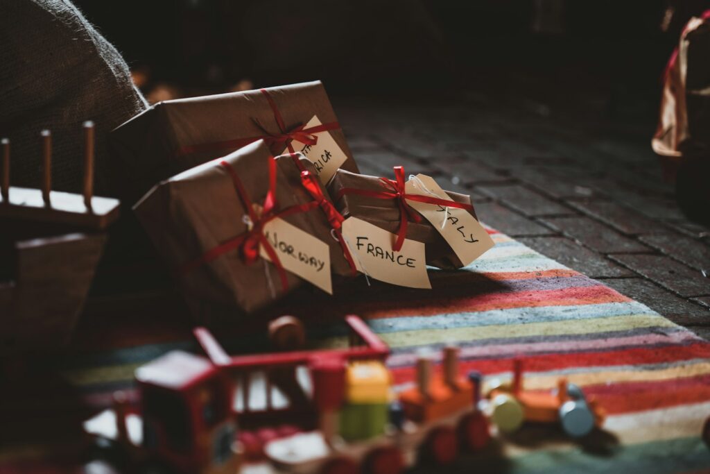 Ingepakte cadeaus en houten speelgoed op een vloer bij een kind