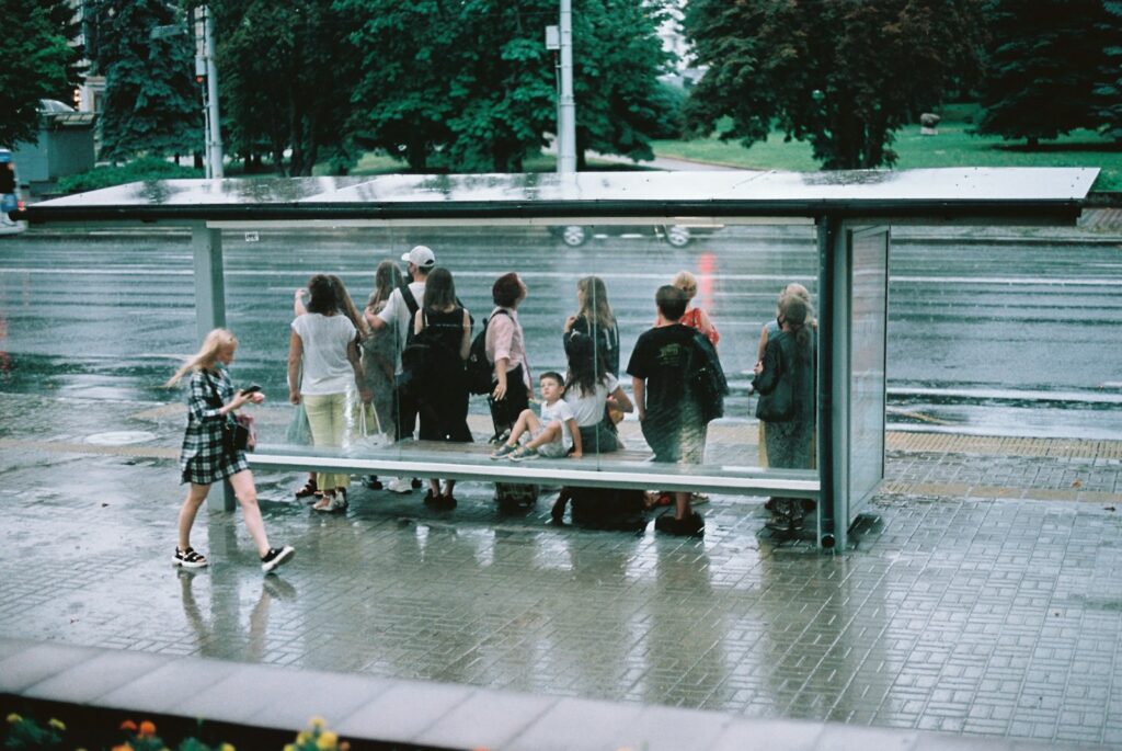 Kinderen met schooltassen wachten bij een bushalte