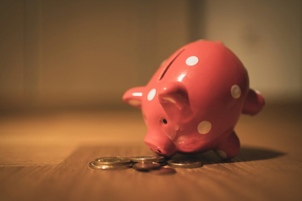 Kind doet munten in een spaarpot op tafel