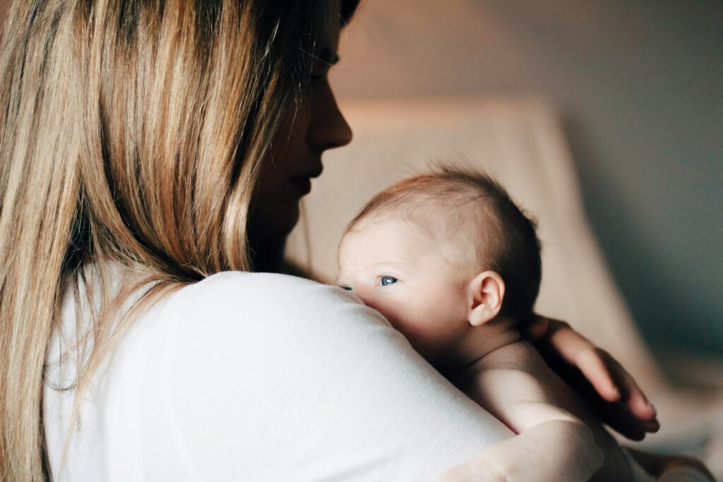 Moeder geeft haar baby borstvoeding in een lichte kamer