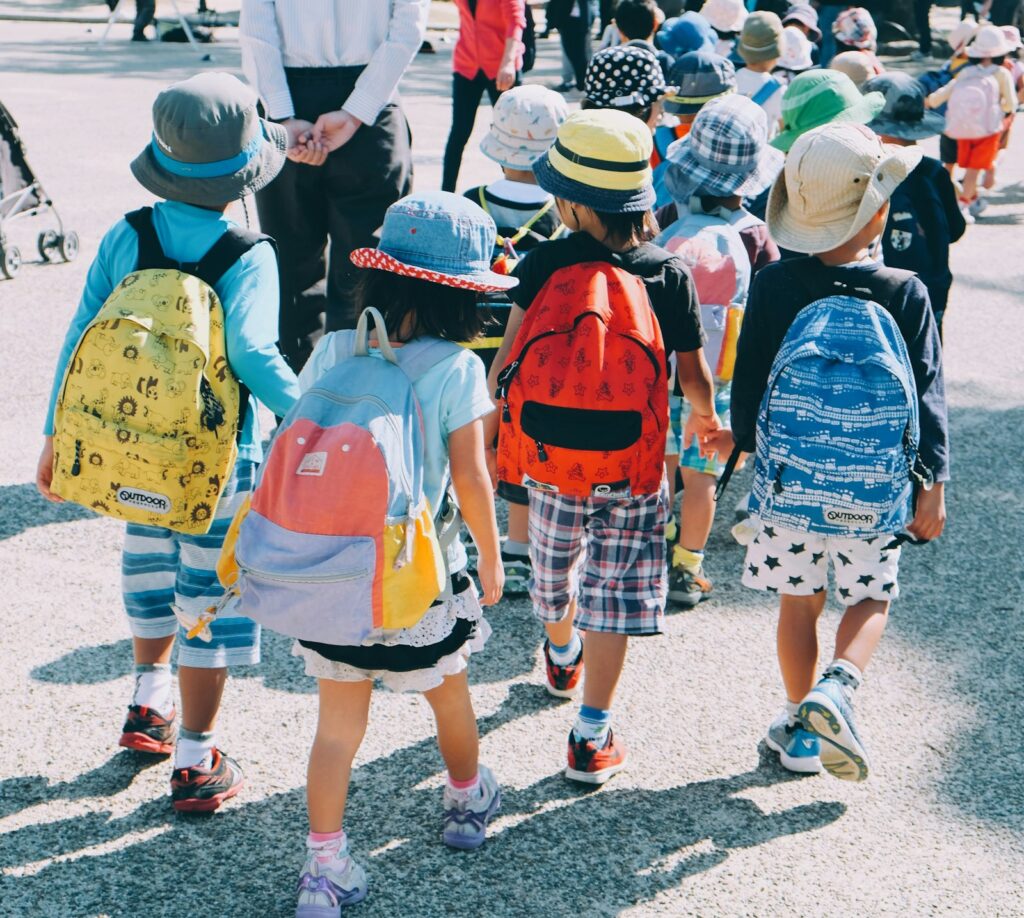 Ouders lopen mee met een groep kinderen tijdens een schooluitje