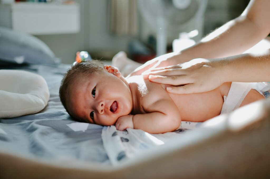 Stapel wegwerpluiers op een commode naast een baby